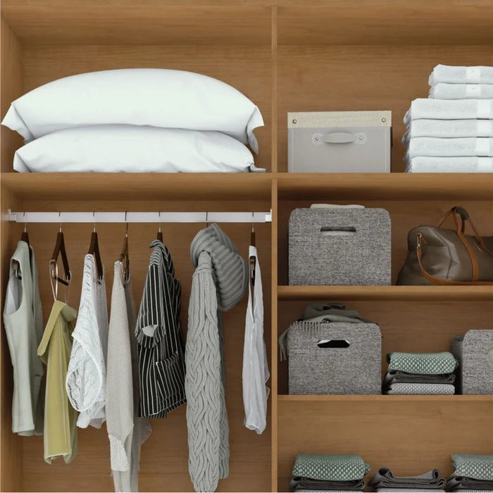 Detalhe interno de guarda-roupa em madeira com cabideiro, prateleiras, roupas e caixas organizadoras